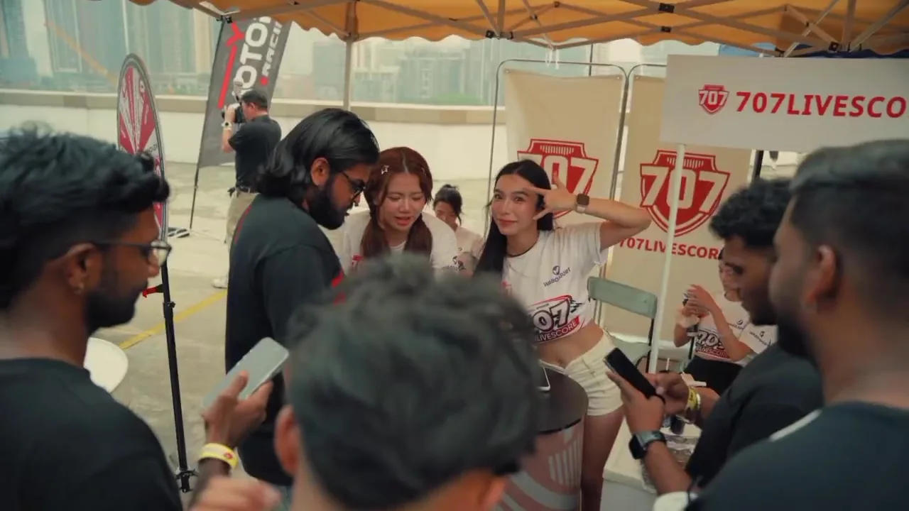 Visitors with phones gathered beside models at the branded 707Livescore counter